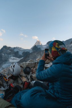 A mountaineer captures the iconic Matterhorn view near Zinalrothorn, Swiss Alps clipart