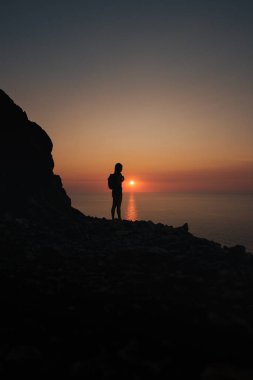 Bir yürüyüşçü, Mallorca 'daki Akdeniz' de gün batımına karşı gölgede kaldı..