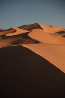 Gün batımında Merzouga, Fas yakınlarında erg chebbi 'nin kum tepeleri boyunca uzanan gölgeler.