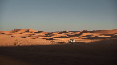 Beyaz off road aracı Merzouga Çölü, Fas 'taki büyüleyici erg chebbi kumullarında ilerliyordu.