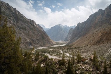 Görkemli dağlar ve yemyeşil vadi bulutlu bir gökyüzünün altında