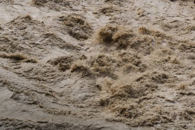 Çamurlu su sel sırasında akıntıya kapılıp güçlü ve yıkıcı bir doğa gücü yaratıyor.