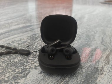 Siyah renkli TWS ya da Kulak Tomurcukları taşıyor. Bluetooth Kulaklık.