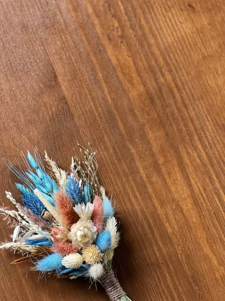 Ahşap masada kurumuş renkli çiçekler.