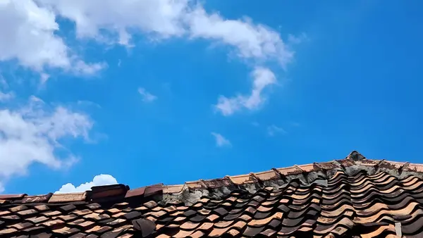 stock image house roof with blue sky and clouds