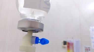 Hastanın odasındaki Saline Intravenous Drip direğinin sinematik görüntüsü. Sağlık ve Tıp Konsepti.