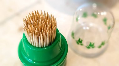 Kürdanlar plastik kutunun içinde. Bambudan yapılmışlar. Kişisel sağlık ve temizlik kavramı. Sığ alan derinliğiyle yakın plan.