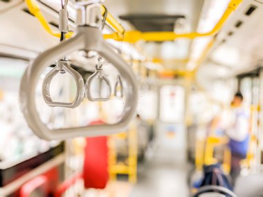 Seyahat sırasında yolcuların güvenliğini sağlamak ve onları rahatlatmak için çok gerekli olan toplu taşıma araçlarında el tutucunun bulanık ön planı ve izole edilmiş odağı.