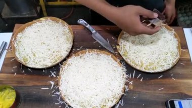 Sinematik çekim. Peynir, fıstık, çikolata ve tatlı sütle doldurulmuş Martabak Keju olarak bilinen tatlı peynirli tavada kızartılmış hamur işi. Endonezya mutfağının tanınmış yemeklerinden biri.