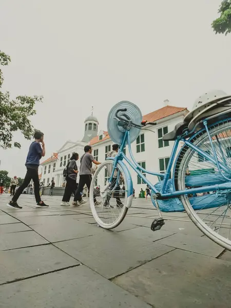 Düşük açı. Öğleden sonra Kuzey Jakarta, Endonezya 'daki Fatahillah Müzesi meydanında parlak mavi bir klasik bisiklet ve eşsiz bir şapka.