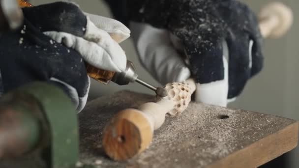 木匠们手戴防护手套 用电动手工研磨机从一块木头上研磨产品 在车间加工木料的过程中 刨花的方向在飞扬 — 图库视频影像