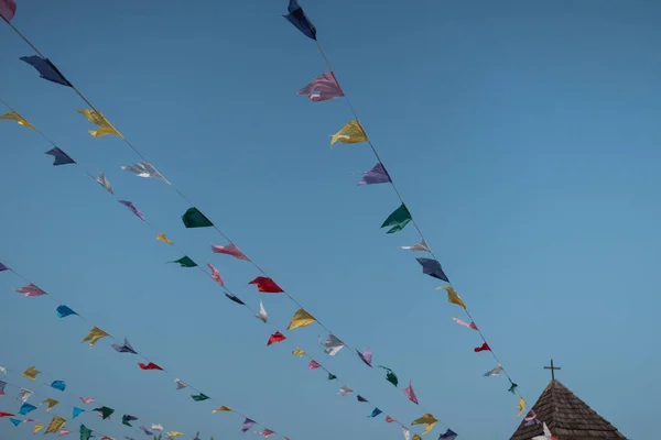 stock image Colorful garlands of flags against the sky flutter from the wind and adorn the summer street food festival. Celebrations near the medieval castle