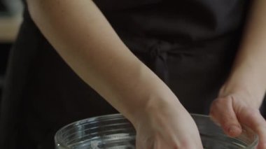 Aşçı elleri cam bir kaptan bir parça peynir hamuru alır ve avuçlarının arasına küçük bir top yuvarlar. Tuzlu kurabiye yapma süreci, yemek tarifi...