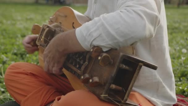 音乐家们的手在草坪上弹奏着木制的高低音 乌克兰古代手工制作的弦乐民谣乐器近景 — 图库视频影像