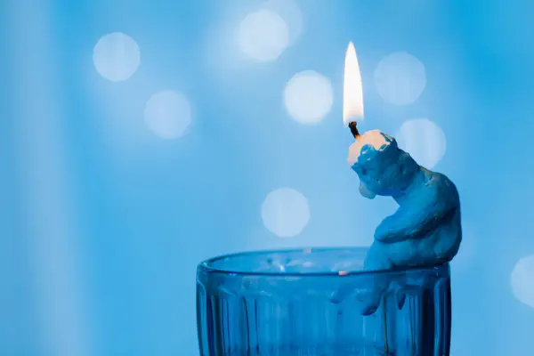 Ένα Ειδώλιο Ένα Αναμμένο Κερί Κάθεται Δυστυχώς Στην Άκρη Ενός — Φωτογραφία Αρχείου