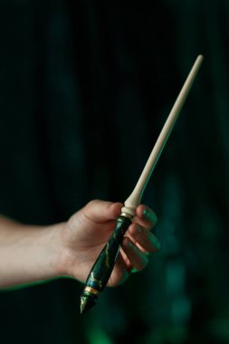 Sihirbazlar parmaklarında sihirli bir değnek tutuyorlardı. Mecazi olarak zümrüt desenli tahtadan oyulmuş. Hogwarts Legacy Cosplay Miras Kalıntısı Dikey Yakın Çekim