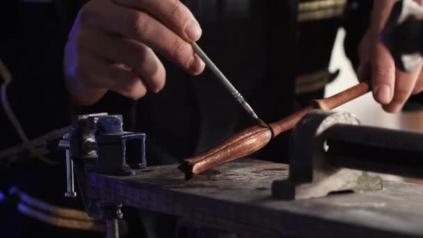 職人の手は 手作りの木製の杖を覆い ブラシを使用したステンドダークソリューションを採用しています カーペントリーワークショップのクローズアップ — ストック動画