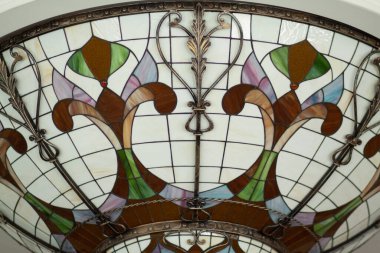 Boyalı cam geometrik desenli monogramlı bir süs şeklinde tavan dekorunun bir parçası. İç tasarım, dekorasyon ayrıntıları