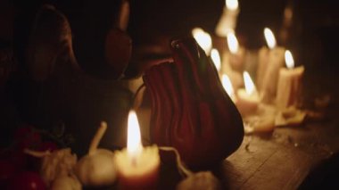 Tavernada, yanan mumların arasındaki tabakların yanındaki tahta masanın üzerinde antik deri para kesesi. Günlük yaşamın tarihsel yeniden inşası, yavaş çekimin yakın çekimi