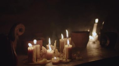 Eski kaba ahşap bir masa üzerinde bir sürü mum yanıyor ve tabaklar toprak kaplarda buharlaşıyor. Ortaçağ 'ın tarihi yeniden yapılandırması, taverna, yavaş 4k