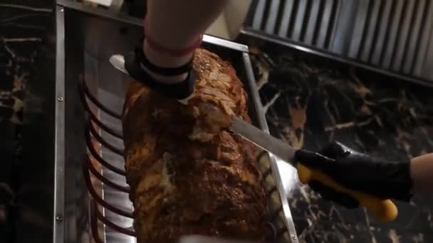 요리사들은 장갑을 뜨거운 고기를 자이로스 기증자 케밥으로 자릅니다 구이에 고기를 — 비디오