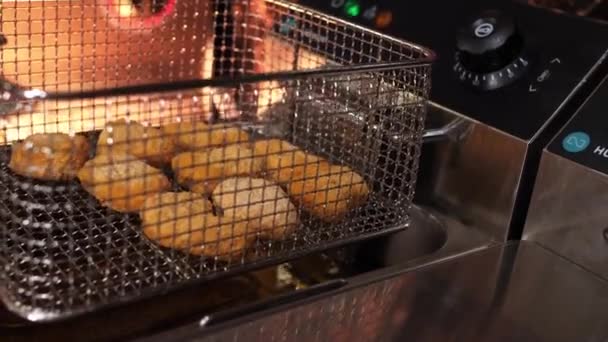 Metal Bir Sepetindeki Çiğ Nuggetlar Yağlı Kabarcıklı Bir Kızartma Makinesine — Stok video