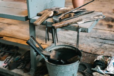 Cam ürünleri üretiminde kullanılmak üzere hazırlanmış bir dizi metal alet. Havalandırma atölyesindeki erimiş camları işlemek için ekipman, yakın plan.