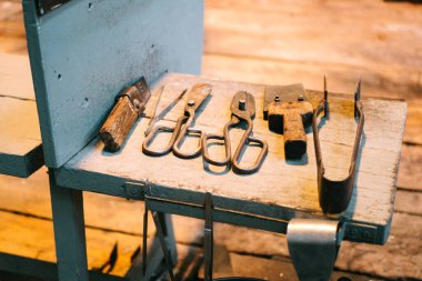 Cam ürünleri üretiminde kullanılmak üzere hazırlanmış bir dizi metal alet. Havalandırma atölyesindeki erimiş camları işlemek için ekipman, yakın plan.