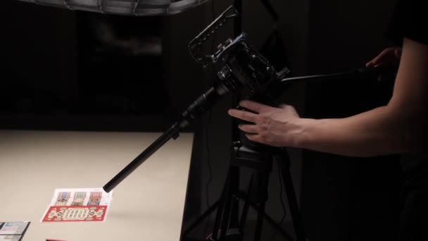 Videografernas Arm Justerar Fokus För Makrolinsen Som Syftar Till Samling — Stockvideo