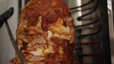 Elleri siyah eldivenlerle pişirir, yağlı eti shawarma, gyros, doner kebap yaparlar. Yavaş yavaş şişte et pişiriyorsun. Yüksek kalite FullHD video