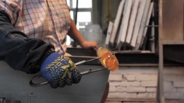 排水沟主的手在工场的工具中形成了一个熔融的玻璃产品 制作玻璃人像的过程 — 图库视频影像