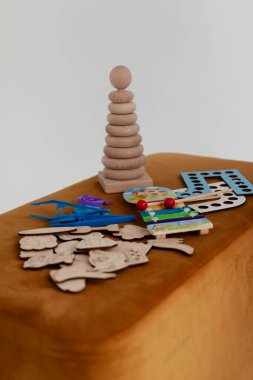 Çocuklu konuşma terapisi dersleri için renkli ve ahşap oyuncaklar küçük bir masanın üzerine serilmiştir. Konuşma geliştirme hazırlığı, eklem bozukluklarının düzeltilmesi, dikey olarak