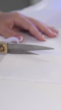 Kesiciler gelecekteki ürünün detaylarını terzi makası ile yavaş çekimde kesiyor. Giysi Hazırlama Süreci, Yakın çekim, Dikey Çekim