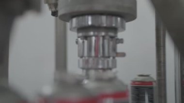 Üretim hattındaki otomatik mekanizma teneke kutuları birer birer boyayla dolduruyor. Taşıma anı, fabrikada optimizasyon işlemi, yakın çekim.