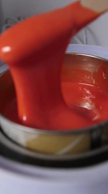 Tüy dökmek için eritilmiş portakal cilası spatuladan erimiş balmumu kasesinin metal kasesine akar. Kozmetik tüy temizleme işlemleri için hazırlıklar, dikey olarak yavaş.