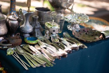 Birçok farklı eski nesneler asfalta yayılmış aydınlık masa örtüleri üzerine serilmiştir. Antika eşyalar bit pazarında ev yapımı tezgahlardan alınıp tekrar kullanılıyor.