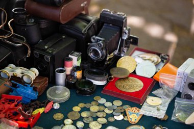Birçok farklı eski nesneler asfalta yayılmış aydınlık masa örtüleri üzerine serilmiştir. Antika eşyalar bit pazarında ev yapımı tezgahlardan alınıp tekrar kullanılıyor.