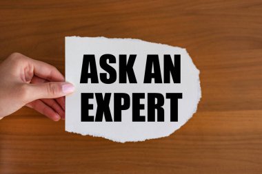 Bir uzmana sor. Kadın eli elinde bir notla bir kağıt parçası tutuyor, bir uzmana sor. Tavsiyeler, sorular, uzmanlık ve bilgi.