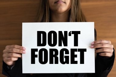 Sakın unutma. Kadının elinde siyah metni olan beyaz bir sayfa var. Hatırlatma, not, motivasyon, iş, mesaj ve tavsiye.