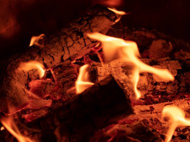 Açık hava şenlik ateşi, yanan odun kütüğü. Yakın çekim şenlik ateşi. Alevler, kor ve yanan odunlar. Aile ve arkadaşlarla sakin bir ortam ve boş zaman aktivitesi.  