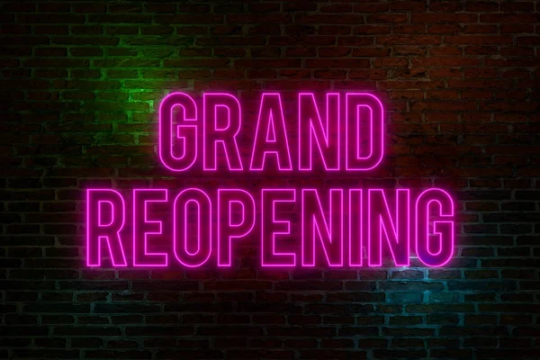 Grand reopening, neon sign. Brick wall at night with the text \