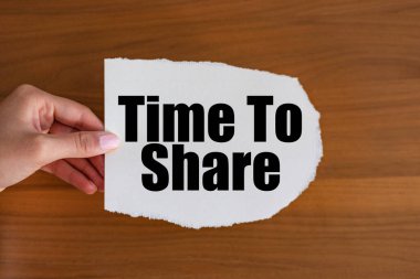 Paylaşma zamanı. Makbuzun üzerindeki metni kapat. Kadın eli bir kağıt parçasını metinle tutuyor.. 