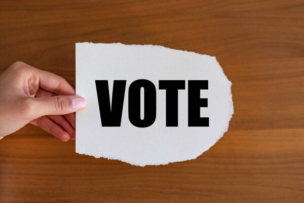 Голосуйте - закрывайте текст на проскальзывании. Женщина держит листок бумаги с текстом. 