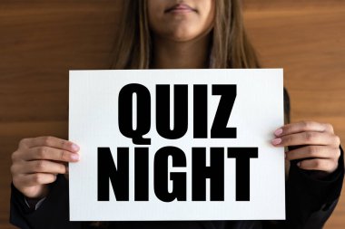 Yarışma Gecesi. Kadının elinde siyah harflerle 