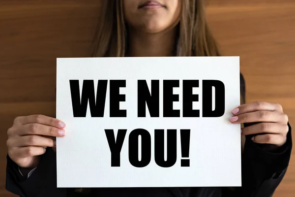 We need you. Woman holds a white page with orange text.  Recruitment, searching, job opportunity, hiring, team, employment and labour.
