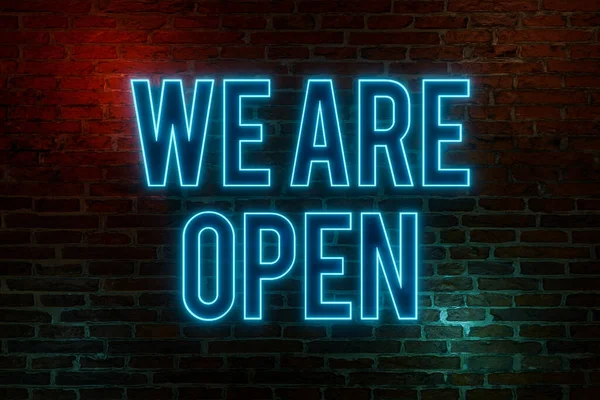 We are open, neon sign. Brick wall at night with the text \