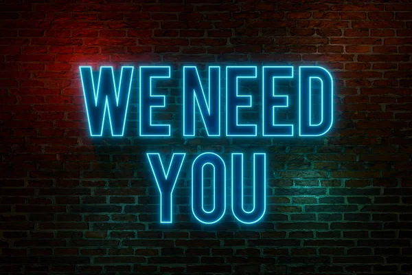 We need you. Neon sign. Brick wall at night with the text \