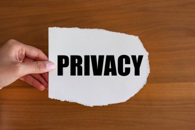 Mahremiyet. Kadın eli, üzerinde bir not olan bir kağıt parçası tutuyor. Sır, yalnızlık; strateji, yargı sistemi, güvenlik duygusu ve durum.