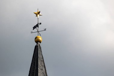 Kilise altın yıldızla dolup taşıyor. Friedrichsdorf, Hochtaunus, Hessen, Almanya Mai 2022. Friedrichsdorf 'taki Protestan kilisesinin kulesi. Altın top ve yıldız tepede.
