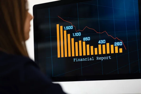 Businesswoman watches a financial report with falling bar chart on the screen. Business data, financial figures, information on the screen. Trading, business, investment, revenues and financial report.